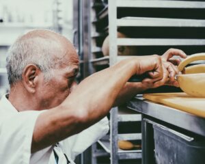 Old man checking the quality of the cheese